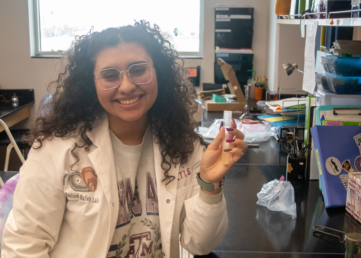 Marisa Gonzalez ‘24, an undergraduate student employee for the Seafood Safety Lab, poses with a sample in the lab.